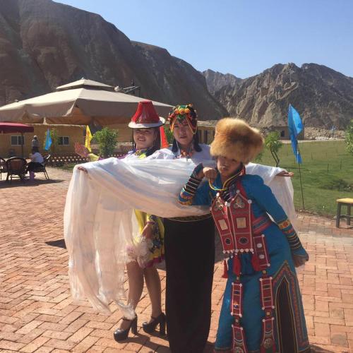 three women dressed in costumes posing for a picture at KaoShan Tent Zhangye in Zhangye