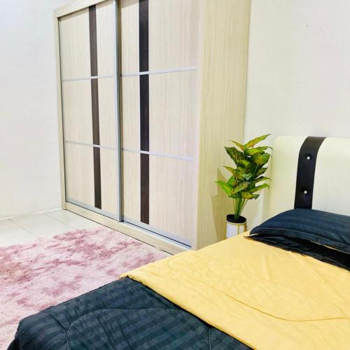 a bedroom with a bed and a large window at Nuria Padang Serai Homestay in Padang Serai