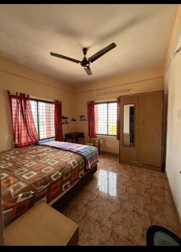 um quarto com uma cama e uma ventoinha de tecto em Serviced apartment with WiFi parking kitchen etc em Bangalore