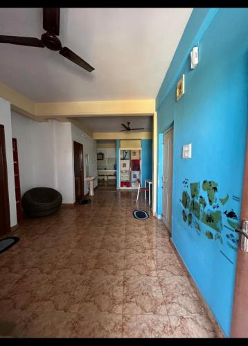 uma sala de estar vazia com uma parede azul em Serviced apartment with WiFi parking kitchen etc em Bangalore