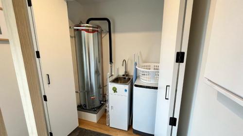 a small room with a water heater and a refrigerator at CBD Luxury 2 Bedroom Retreat in Christchurch
