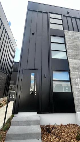 a black door on a black building with stairs at CBD Luxury 2 Bedroom Retreat in Christchurch