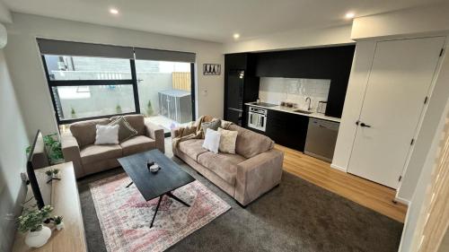 基督城的住宿－CBD Luxury 2 Bedroom Retreat，带沙发和桌子的客厅以及厨房。