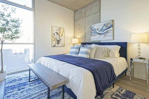 Schlafzimmer mit einem Kingsize-Bett und einer blauen Decke in der Unterkunft Loft Lv8 ※ Elegant Urban Oasis in Downtown Vegas in Las Vegas