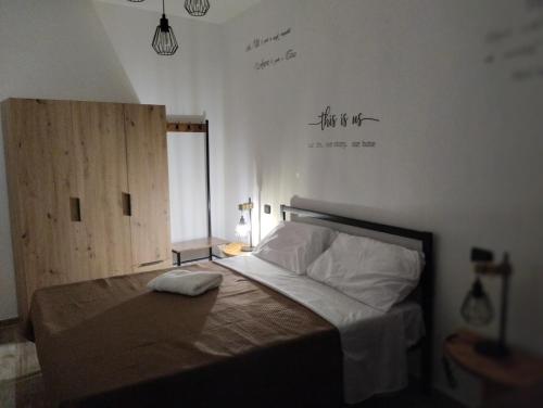 1 dormitorio con 1 cama con un cartel en la pared en La Casa dei Ricordi, en Campagnano di Roma