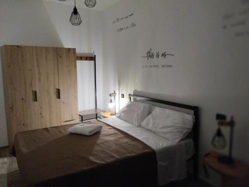 a bedroom with a bed with a sign on the wall at La Casa dei Ricordi in Campagnano di Roma