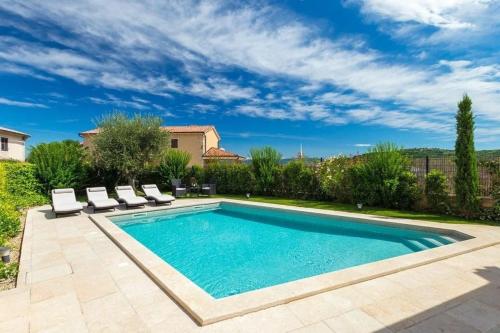 a swimming pool with two lounge chairs and a house at Ferienhaus mit Privatpool für 8 Personen ca 200 qm in Kaldir, Istrien Motuvun und Umgebung in Motovun