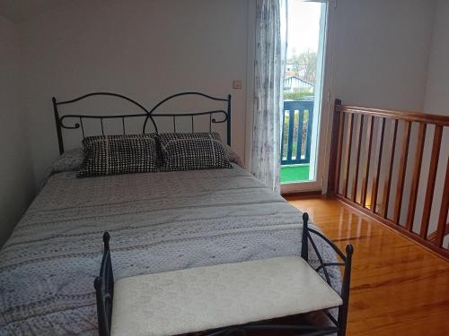 ein Bett in einem Schlafzimmer mit einem großen Fenster in der Unterkunft Maison Hendaye, 3 pièces, 4 personnes - FR-1-239-1034 in Hendaye