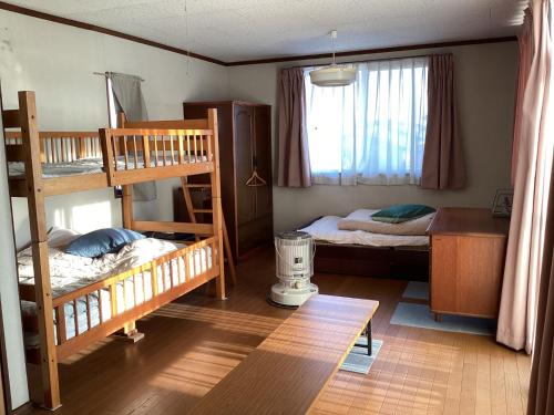 Ichihara的住宿－Ichihara City - House - Vacation STAY 15268，客房设有两张双层床和一张书桌。