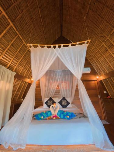 a bedroom with a bed with a canopy at Harta Lembongan Villas in Nusa Lembongan
