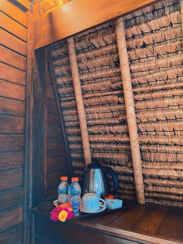 a shelf with a tea kettle and bottles of water at Harta Lembongan Villas in Nusa Lembongan