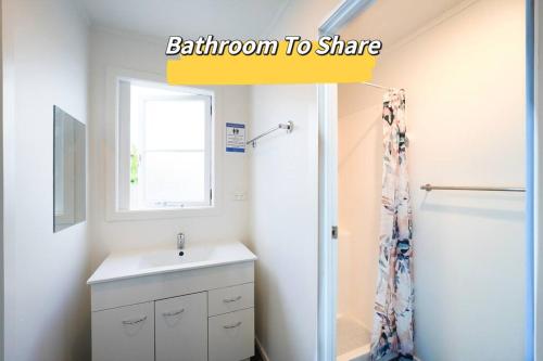 baño con lavabo, ventana y ducha en 5-Bedroom Fully-Equipped Home in Whangarei, en Whangarei