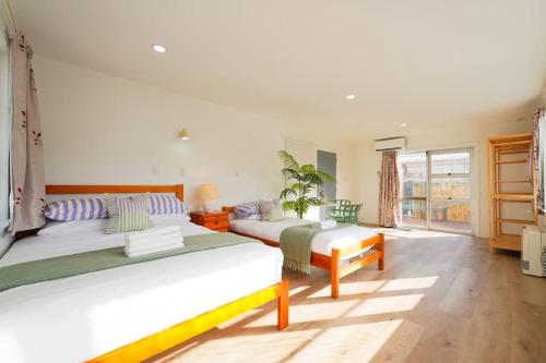 1 dormitorio con 2 camas y ventana grande en 5-Bedroom Fully-Equipped Home in Whangarei, en Whangarei