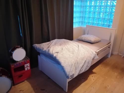 Cama pequeña en habitación con ventana en Naza cool villa! en Malmö