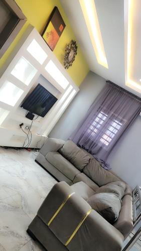 a living room with a couch and a window at Fortune Solar Hotel in Abuja