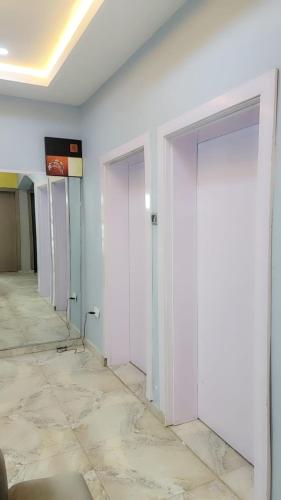 una fila di porte in una stanza con pavimento piastrellato di Fortune Solar Hotel ad Abuja