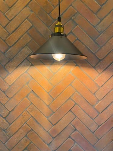 a light fixture hanging from a brick wall at Hotel Boutique Divino Sol in León