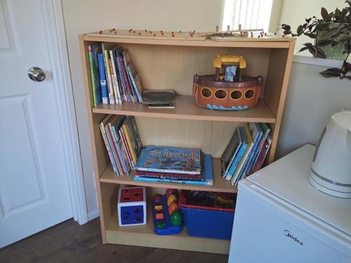 a book shelf with a toy on top of it at Cozy Half Moon Bay Homestay in Auckland