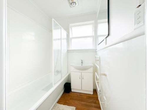 a bathroom with a sink and a mirror at Serene Home in Whangarei in Whangarei