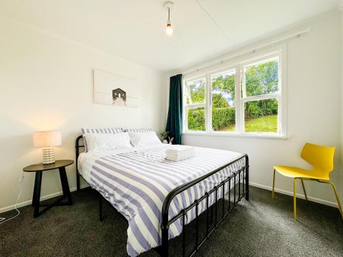 a white bedroom with a bed and a window at Serene Home in Whangarei in Whangarei