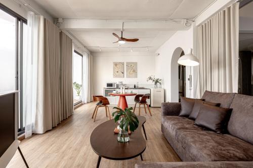 a living room with a couch and a table at The Lair Bangkok - 3mins walk to ICON SIAM in Bangkok
