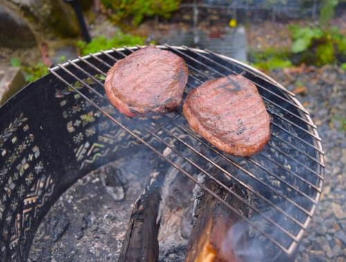 two hamburgers are cooking on a grill at Komorebi/こもれび in Takayama
