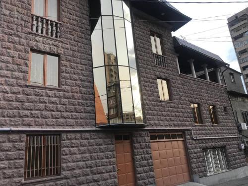 Un edificio alto de ladrillo con una ventana de vidrio. en Asana Tourism and Business, en Ereván