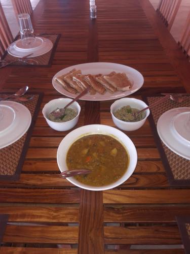 a table with two bowls of soup and some food at Kitelantis Hotel and Resort in Kalpitiya