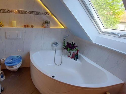 a bathroom with a tub with a window and a toilet at on the Werraufer Modern retreat 