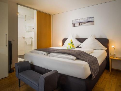1 dormitorio con 1 cama grande y 1 silla en Ferienhaus Sandra en Hörbranz