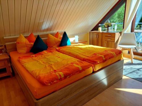 a large bed with an orange comforter in a bedroom at on the Werraufer Modern retreat 