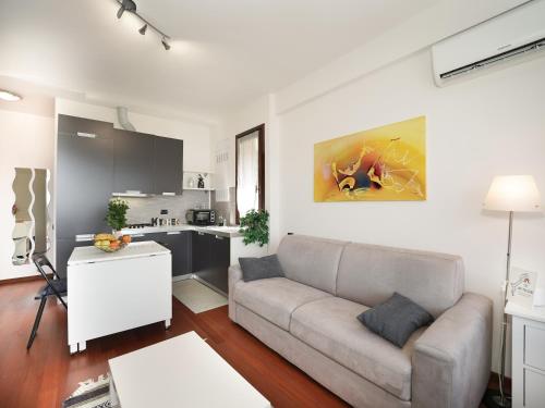 a living room with a couch and a kitchen at Lily Lake Maggiore in Laveno
