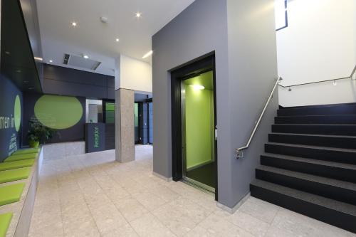 a hallway with stairs and a green door in a building at Economy-Hotel in Ulm
