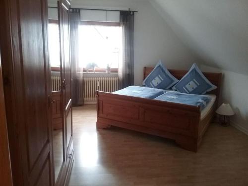 Un dormitorio con una cama con almohadas azules y una ventana en Modern retreat by the lake, en Olsberg