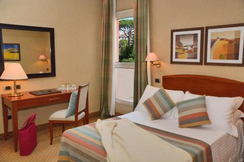 a hotel room with a bed and a desk at LH Hotel Lloyd Roma in Rome