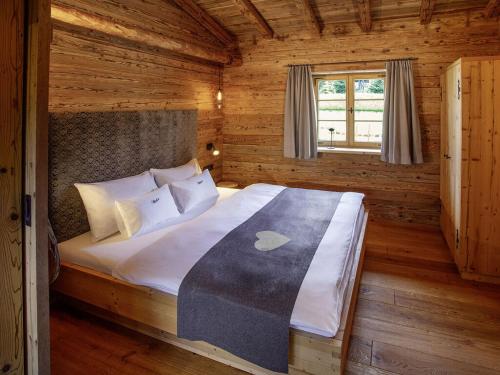 a bedroom with a bed in a wooden cabin at Alpglück Chalet Modern retreat in Oberstdorf