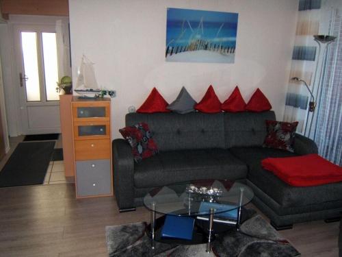 ein Wohnzimmer mit einem Sofa und einem Glastisch in der Unterkunft "Seestrasse" 24 Merchant in Horumersiel