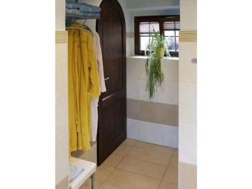 a bathroom with a brown door and a yellow robe at with tower Modern retreat in Scheinfeld