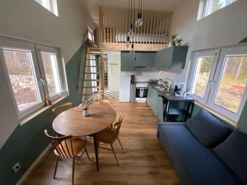 ein Wohnzimmer und eine Küche mit einem Tisch und einem Sofa in der Unterkunft Attefallshus. in Västervik
