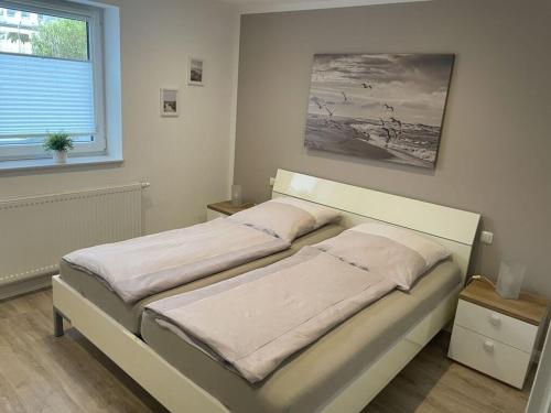 a bed in a white room with a window at This year with lake view in Pönitz am See
