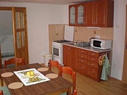 cocina con mesa y cocina con microondas en Ferienwohnung für 8 Personen ca 80 qm in Pernink, Böhmen Skizentrum Pernink, en Pernink