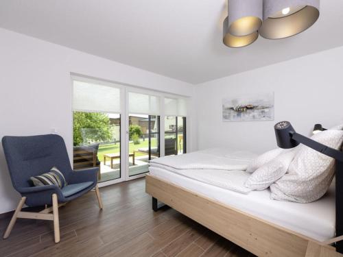 a bedroom with a bed and a blue chair at STAY4 2 Modern retreat in Wunsiedel