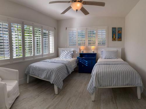 a bedroom with two beds and a ceiling fan at Villa Bayside Beach in Fort Myers Beach