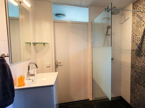 a bathroom with a sink and a shower at Summer Melody Comfortable holiday residence in Julianadorp