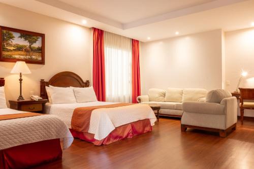 a hotel room with two beds and a chair at Grand Victoria Boutique Hotel in Loja