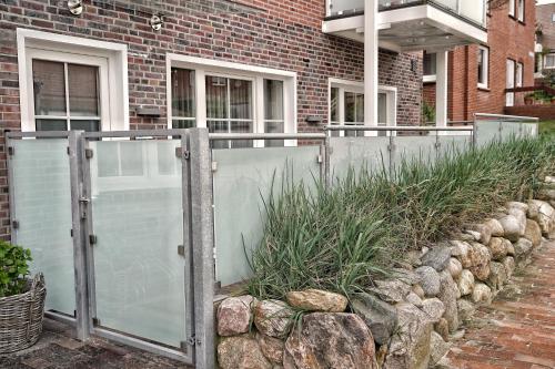 a fence in front of a brick building at Endlich Theda in Juist