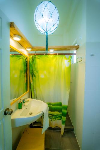a bathroom with a sink and a shower curtain at Trinco Beach by DSK in Trincomalee