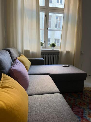 a living room with a couch and a window at Design stay in the heart of Punavuori in Helsinki