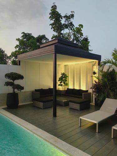 a pavilion with couches and a pool on a building at Bangtao Luxury Pool Villa - Prymana in Phuket