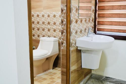 ein Bad mit einem WC und einem Waschbecken in der Unterkunft Kalanad Residency in Kalanādu